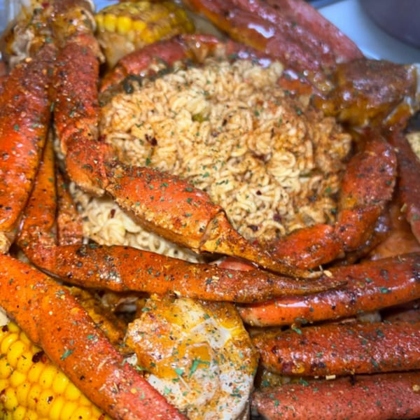 Royal Krabz seafood boil with crab legs, corn, and noodles, seasoned with spices.