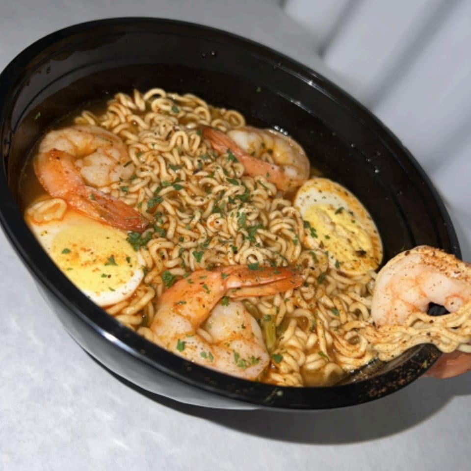 Royal Krabz shrimp ramen with hard-boiled eggs and parsley in a black bowl.